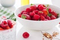 Summer fresh red juicy fruits Ã¢â¬â raspberries and strawberries in a white bowl on a table for breakfast or lunch Royalty Free Stock Photo